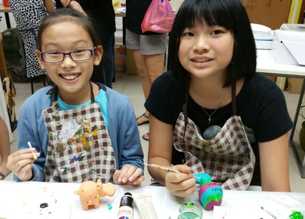 Two kids painting stone hippos. Kids Art Classes - Decorative Painting